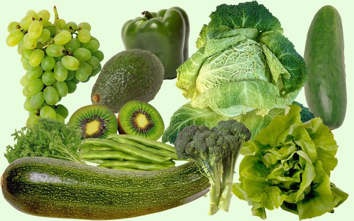 Una variedad de frutas y verduras verdes, incluyendo calabacín, pepino, lechuga, col, brócoli, judías verdes, pimiento, aguacate, kiwi y uvas.