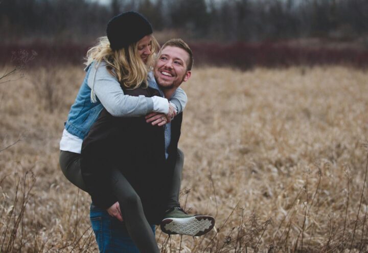 Un hombre que lleva a su esposa en brazos y disfrutan juntos de la naturaleza