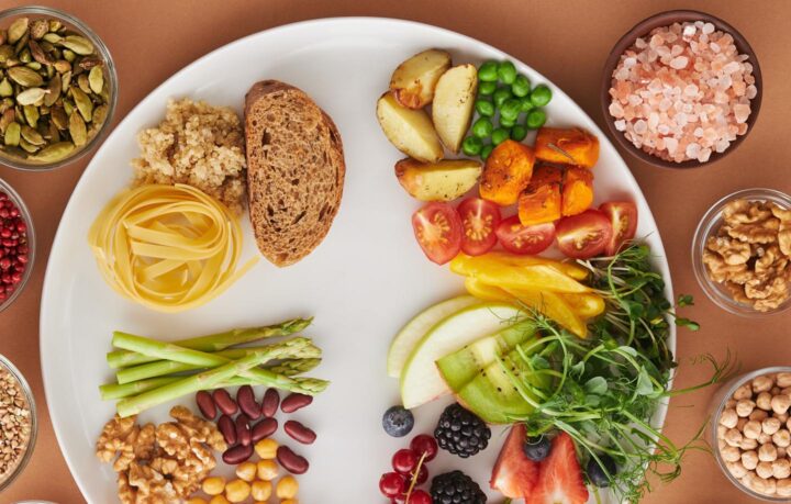 Un plato de frutas, verduras y cereales integrales.